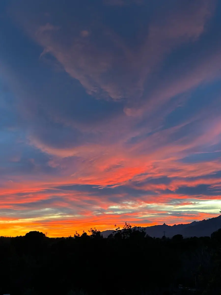 A red and orange sunset sky over the hills